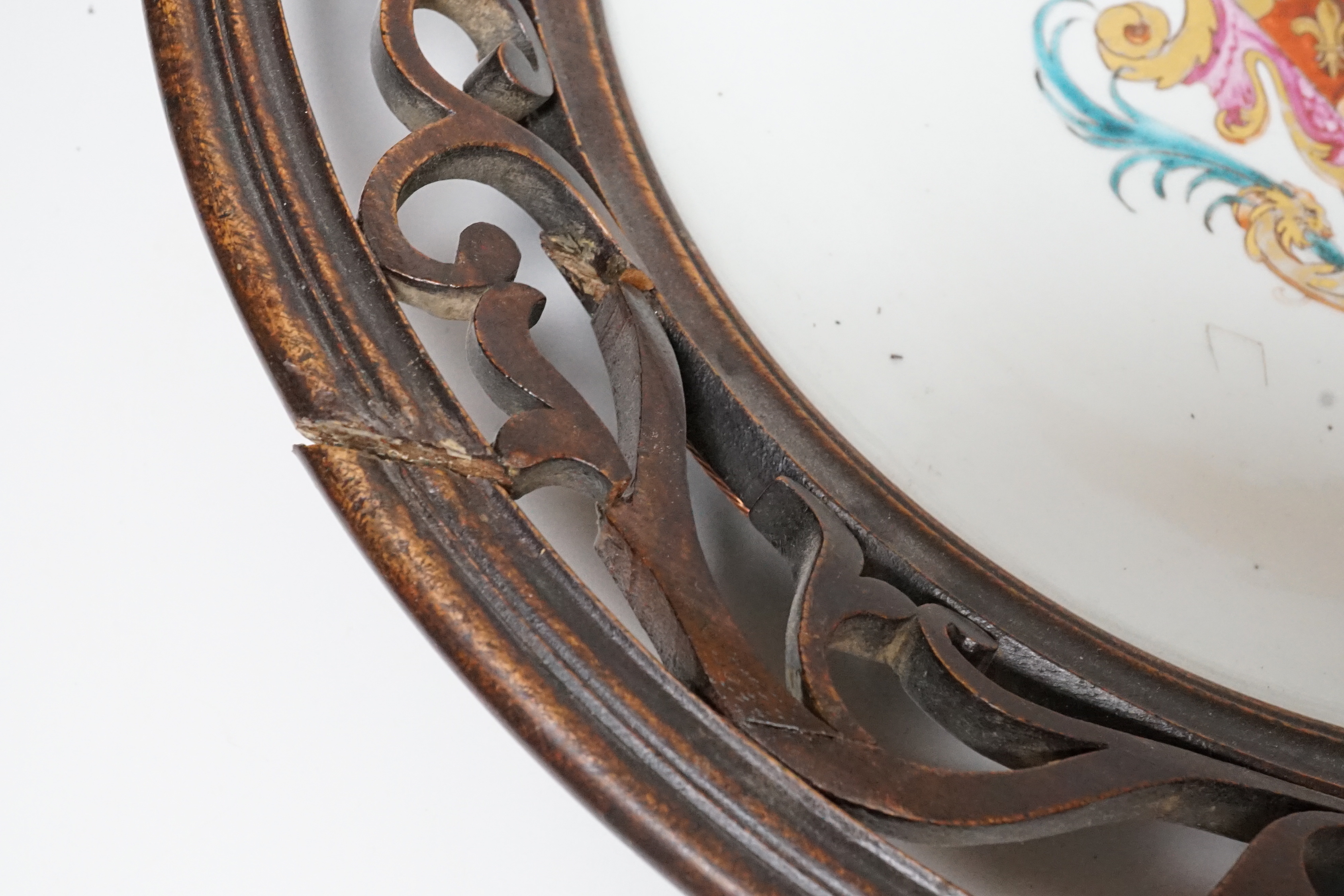 An 18th century Chinese armorial dish, rim cut down and mounted in a 19th century English mahogany frame, 39cm diameter